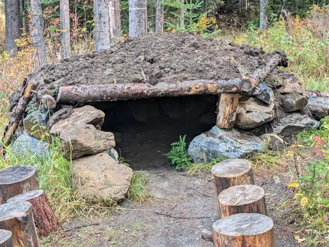 Sod-roofed log bear den on the Bear Byway