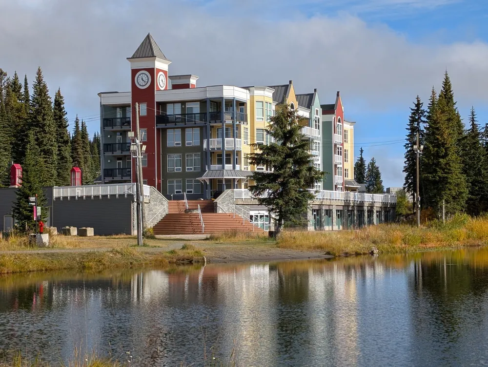 SilverStar lodge with a red brick clock tower reflected in Brewer’s Pond