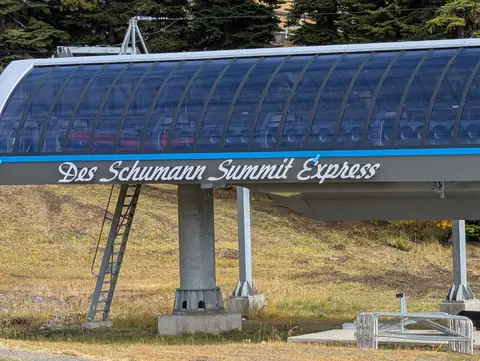 Blue arched lift terminal lettered Des Schumann Summit Express