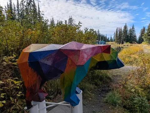 The faceted bear’s blue and purple side beside the trail in fall