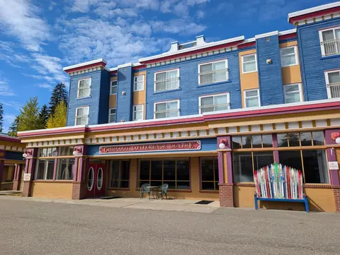 Pink, blue and gold storefront with a bench made from colourful skis