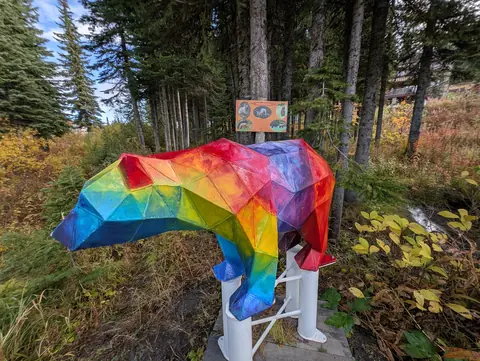 Close view of the rainbow faceted bear with autumn leaves behind