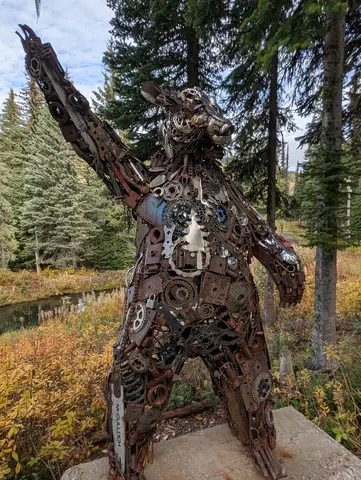Scrap-metal standing bear with one arm raised in fall