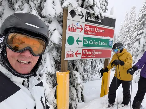 Sean smiling beside trail markers for Silver Queen and Criss Cross