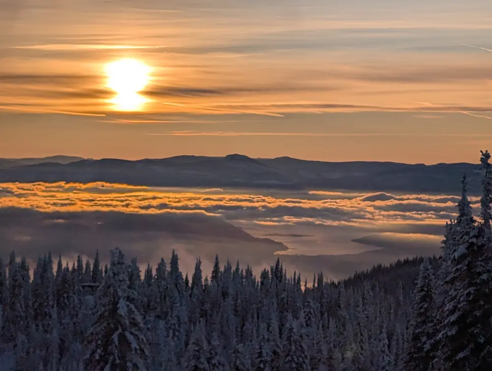 Sun setting over a sea of golden cloud below SilverStar Mountain Resort