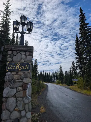 Stone pillar with a lamp and a sign reading the Knoll