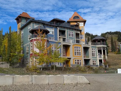 Blue, green and gold turreted lodge with yellow aspens